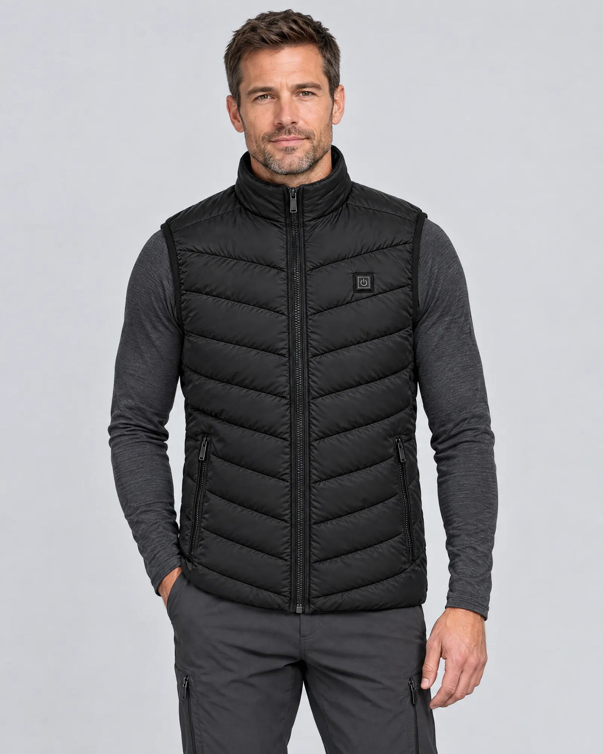 Model wearing the Treeline men's heated vest over a charcoal base layer, front view