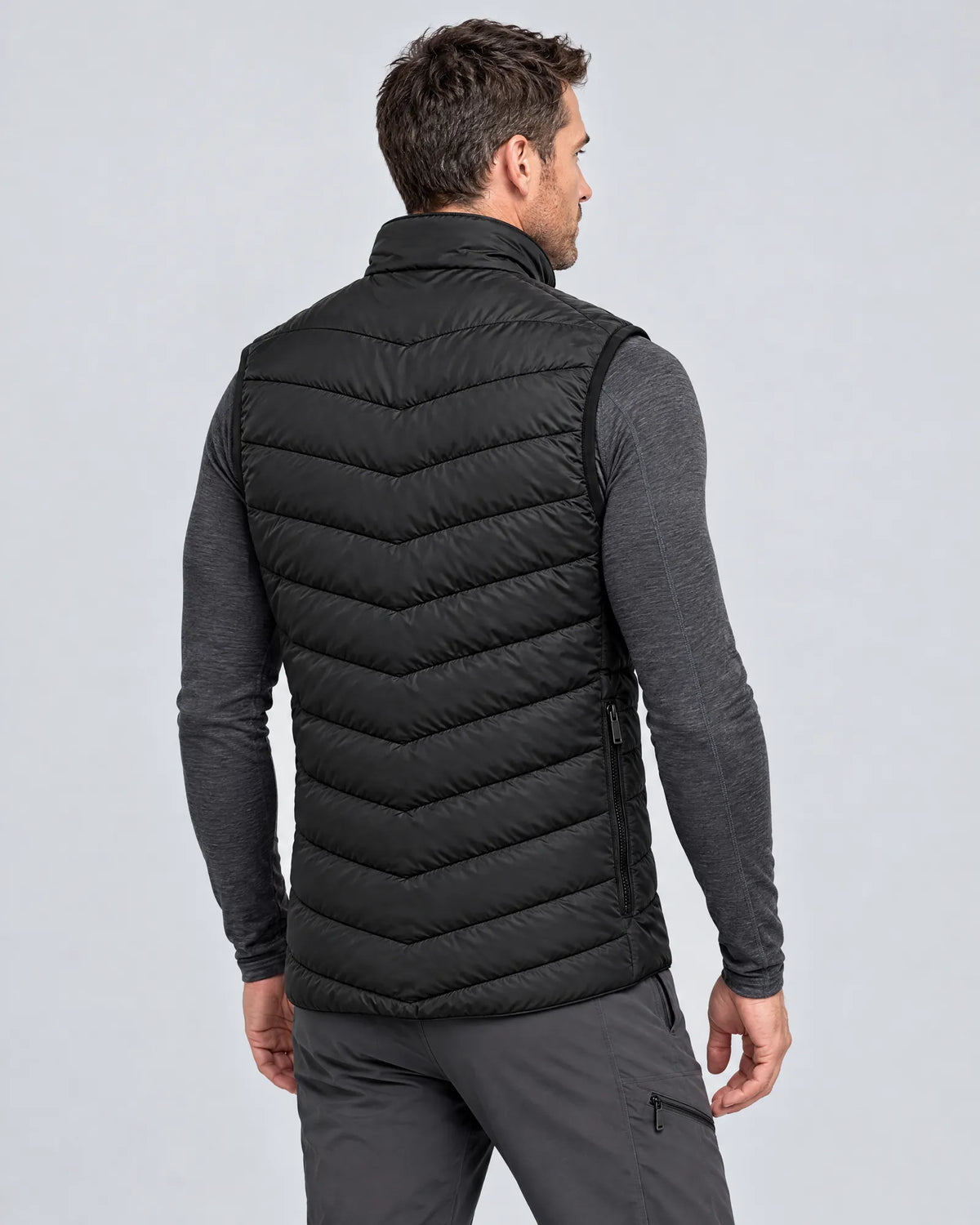 Model wearing the Treeline men's heated vest, three-quarter back view