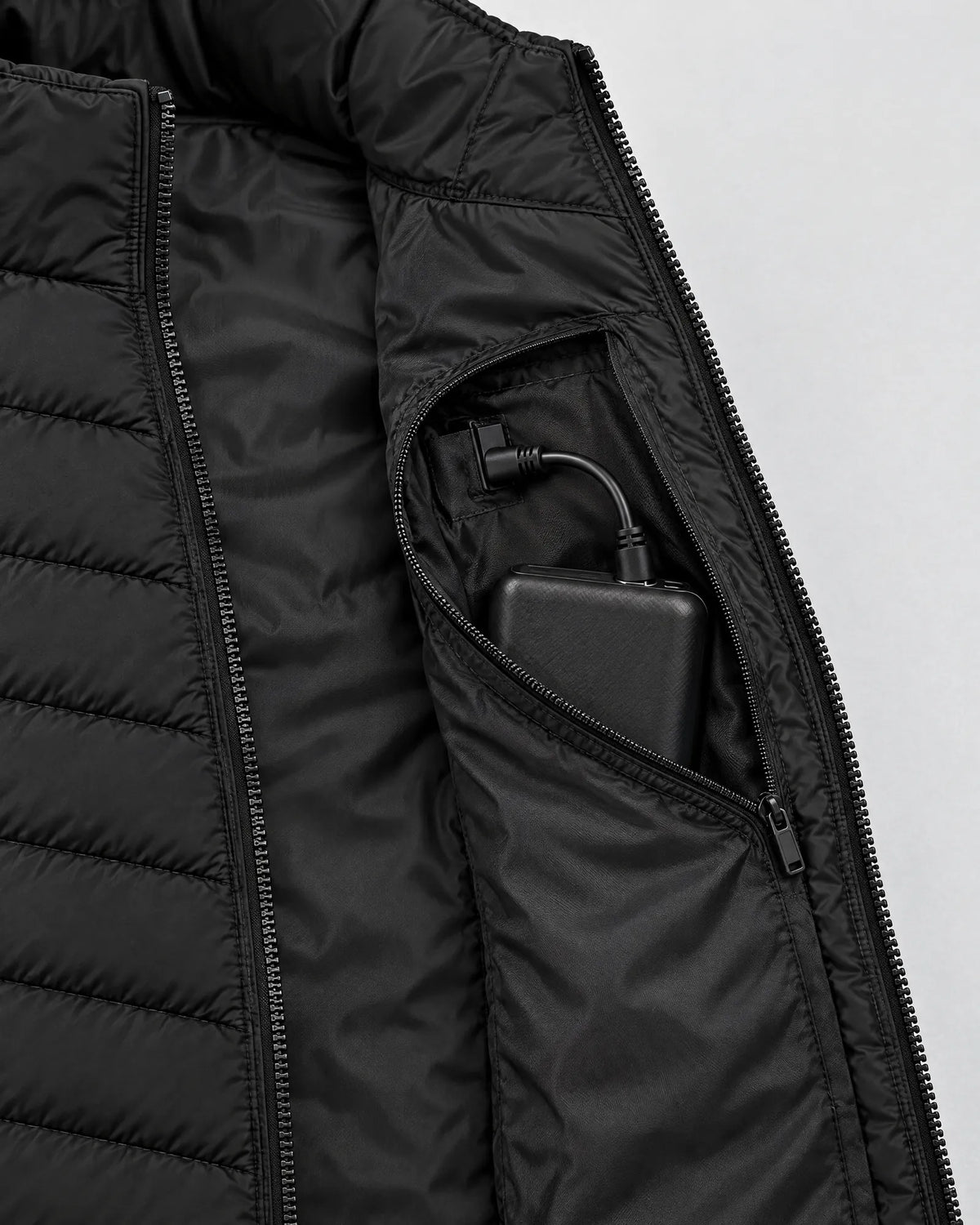 Inner pocket of the Treeline vest holding the power bank with the cable connected