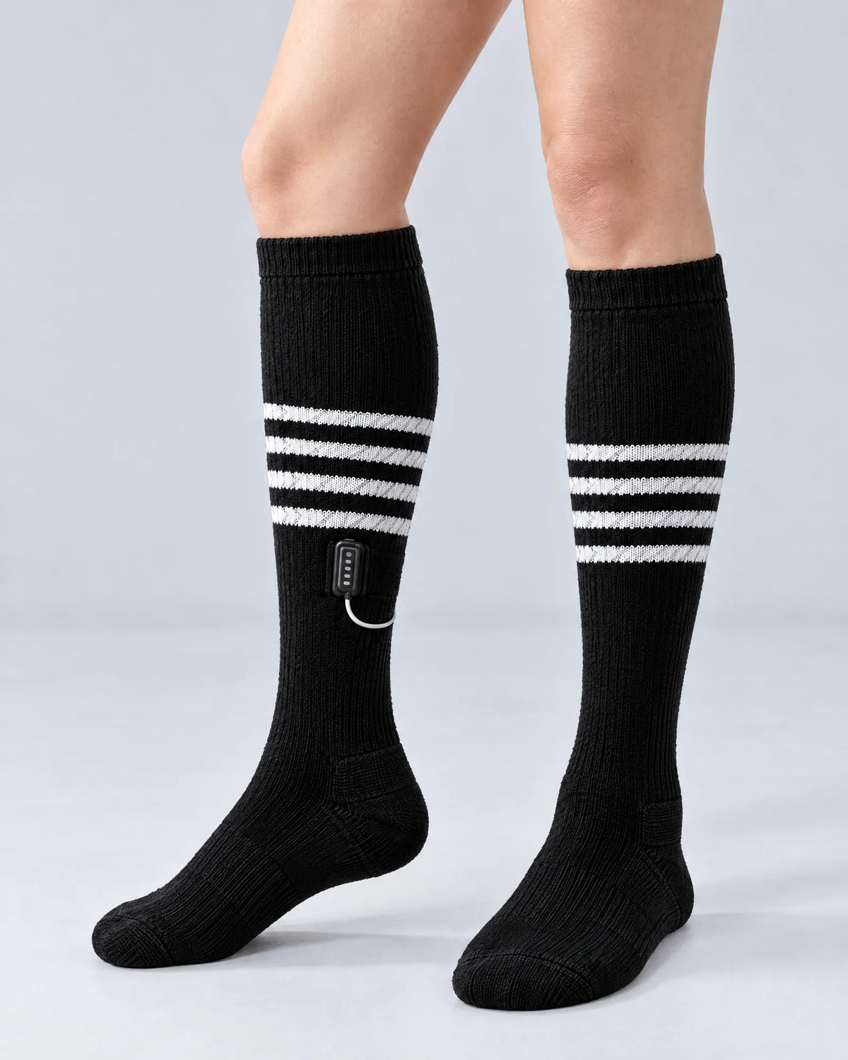Switchback heated socks worn on the leg, showing the battery pocket on the outer calf