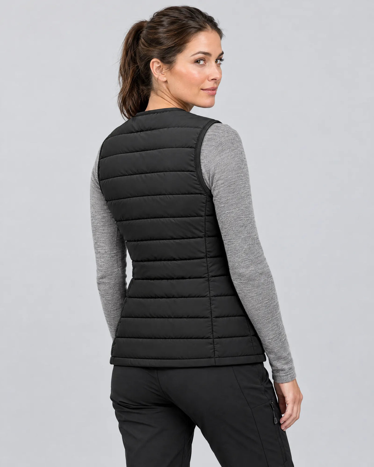 Model wearing the Ridgeline women's heated vest, three-quarter back view